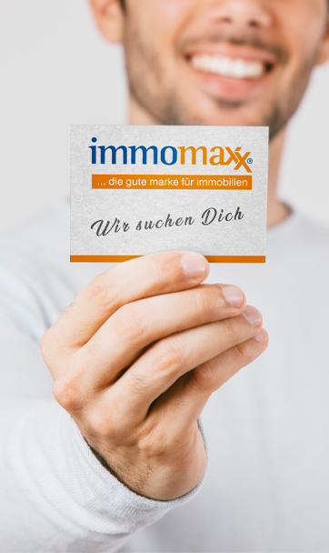 Mann mit Visitenkarte von immomaxx in der Hand, Schriftzug "Wir suchen Dich"