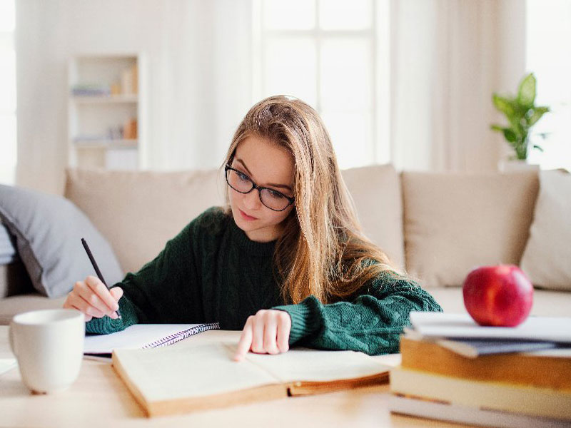 Studentin mit Buch beim Lernen